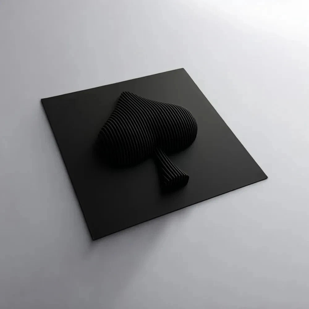 Black abstract sculpture on a black square platform against a gray background