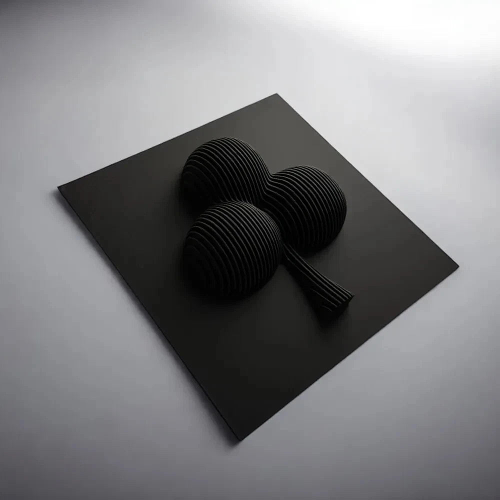 Black three-dimensional abstract sculpture on a gray surface