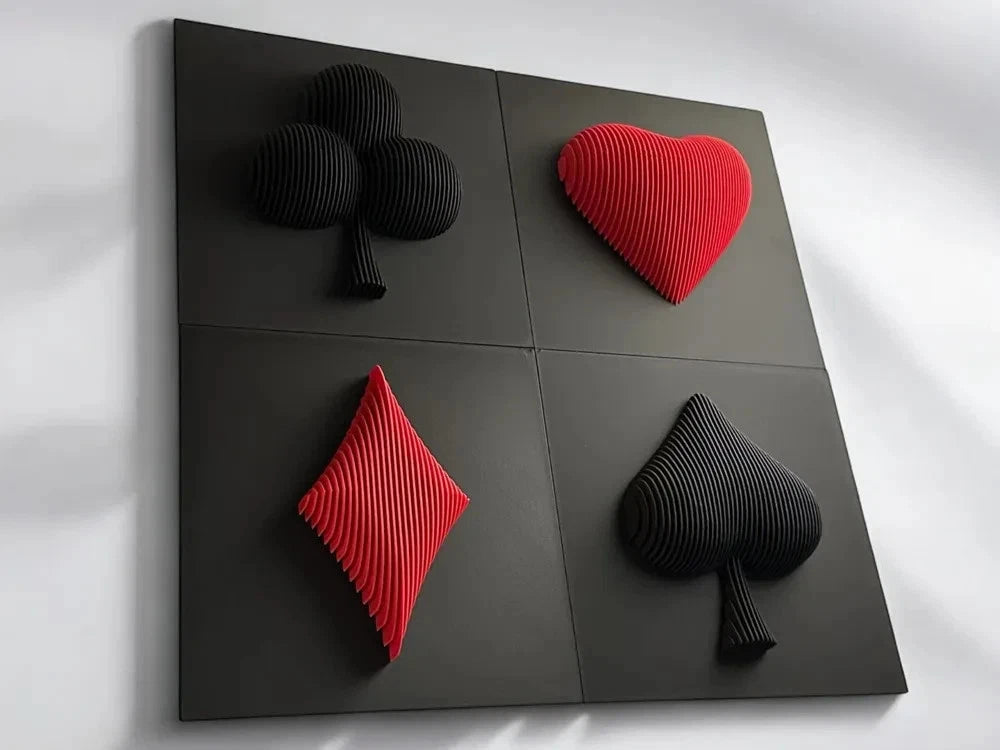 Four playing card suits (clubs, hearts, diamonds, spades) on a black surface with a white background