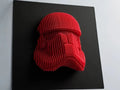 Red stormtrooper helmet sculpture on a black background