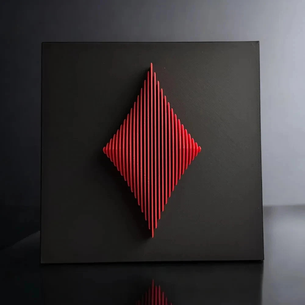 Red geometric sculpture on a black surface with a dark background